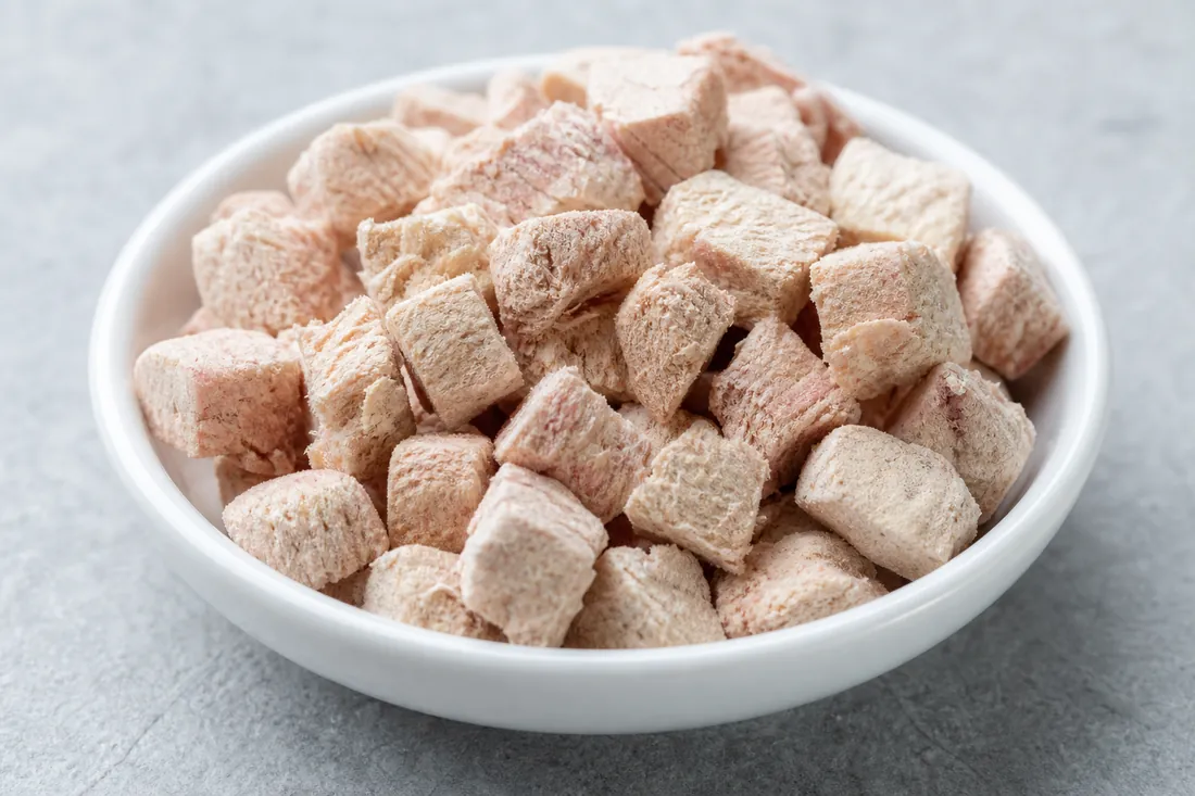 Close-up of freeze-dried raw pet food morsels in a small white dish