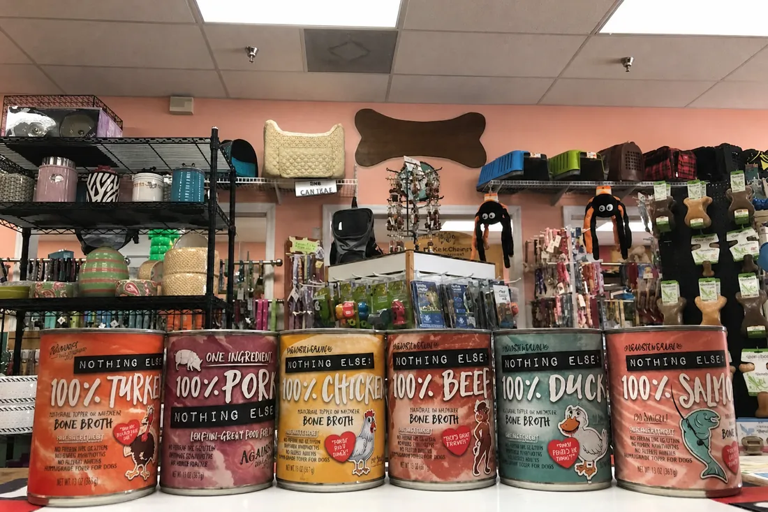 A row of single-ingredient canned pet foods on the counter at Paradise Poochie